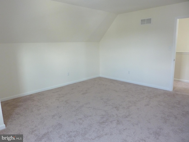 bonus room featuring light carpet and vaulted ceiling