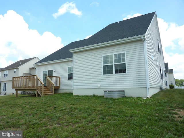 back of property with a wooden deck and a lawn