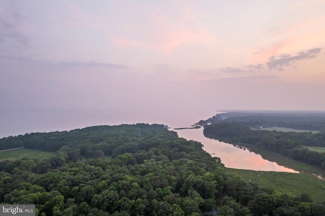 aerial view at dusk featuring a water view