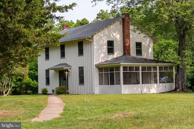 view of front of home with a sunroom and a front lawn