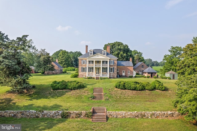 rear view of property featuring a lawn