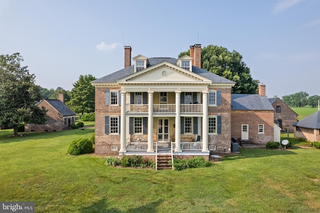 back of house with a balcony and a lawn