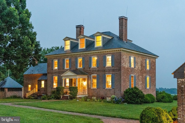 colonial house with a front lawn and covered porch