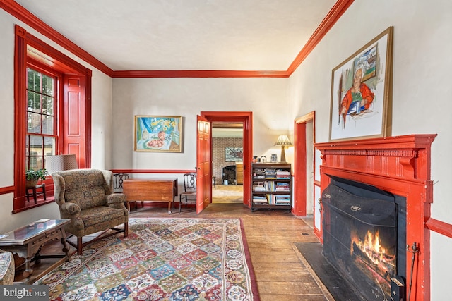 sitting room with dark hardwood / wood-style floors and crown molding