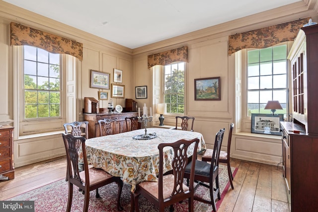 dining room with crown molding and light wood-type flooring