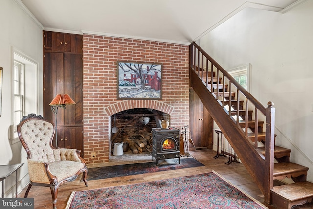 living room featuring ornamental molding, light wood-type flooring, and a wood stove