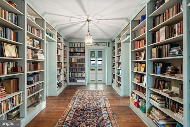 living area with ornamental molding, dark hardwood / wood-style flooring, and built in shelves