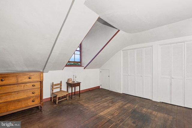 bonus room featuring vaulted ceiling and dark wood-type flooring