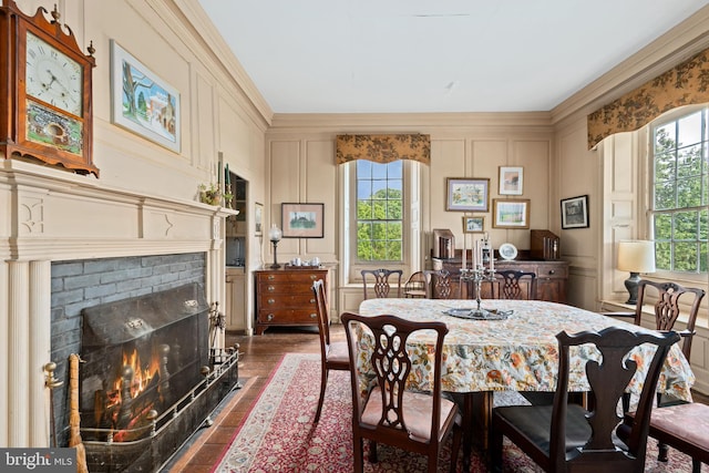 dining room with a wealth of natural light, ornamental molding, dark hardwood / wood-style floors, and a fireplace