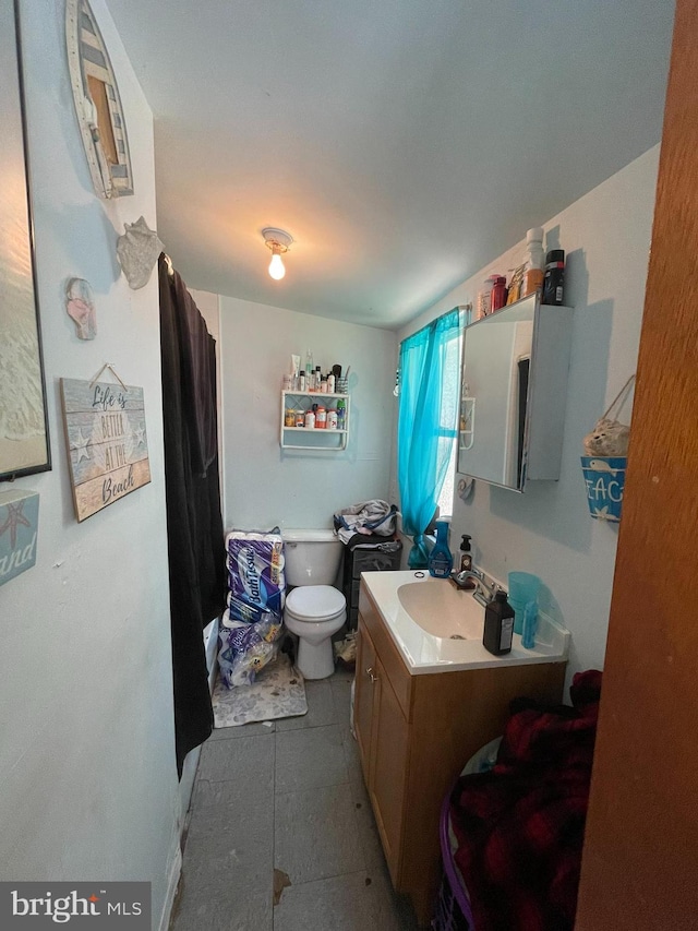 bathroom with tile floors, toilet, and vanity