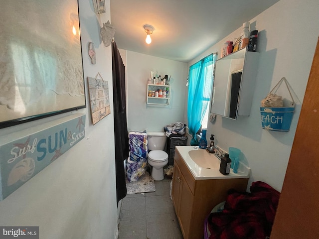 bathroom with vanity, tile floors, and toilet