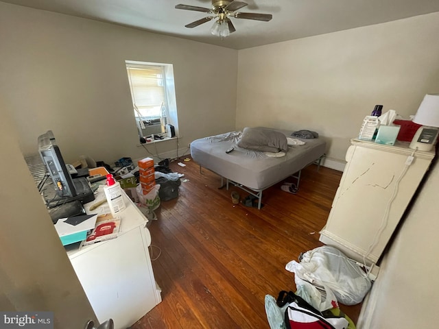 bedroom with dark hardwood / wood-style floors and ceiling fan