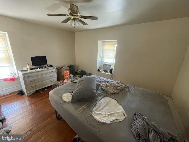 bedroom featuring wood-type flooring, ceiling fan, and radiator heating unit