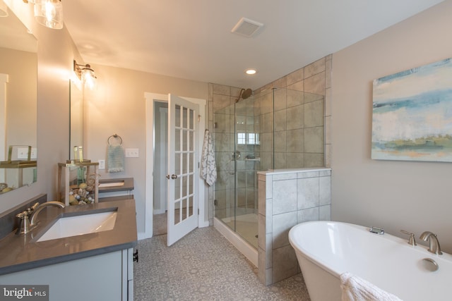 bathroom featuring shower with separate bathtub, oversized vanity, and french doors