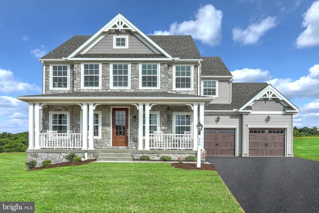 view of front of house with a porch, a front yard, and a garage