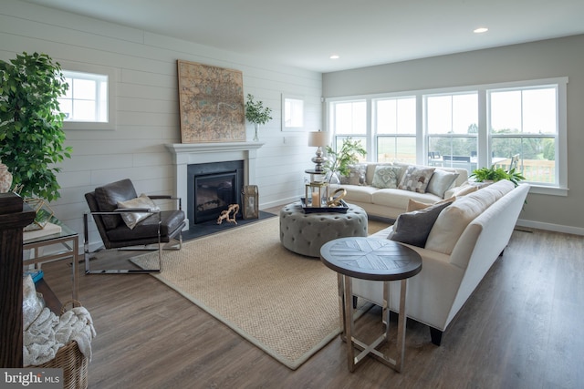 living room with dark hardwood / wood-style flooring and wooden walls