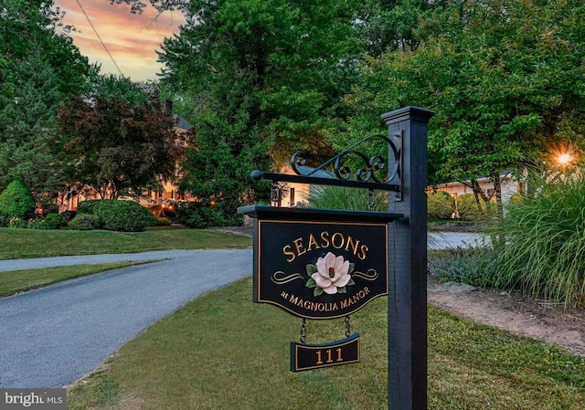 community / neighborhood sign featuring a yard