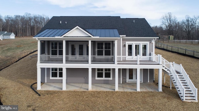 back of property with a deck, a patio, and french doors