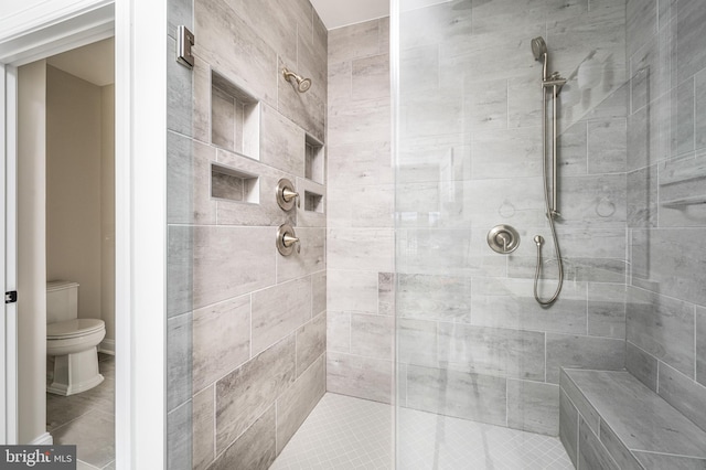 bathroom with toilet and tiled shower