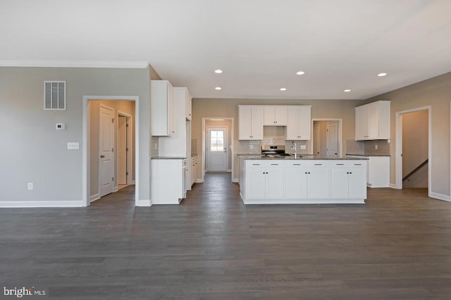 kitchen featuring white cabinets, dark hardwood / wood-style floors, and a center island with sink