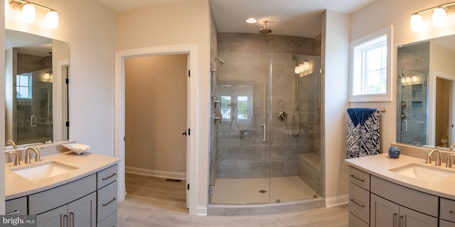 bathroom featuring a shower with shower door and vanity