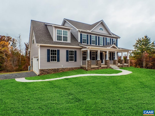 view of front of property featuring a front lawn, a porch, and a garage