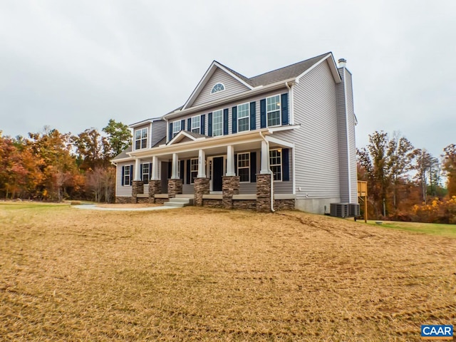 view of front of house with a front yard, a porch, and central air condition unit