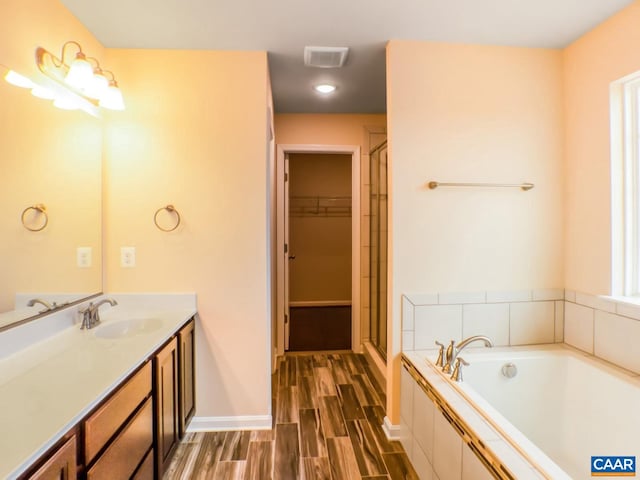 bathroom featuring hardwood / wood-style floors, vanity, and independent shower and bath