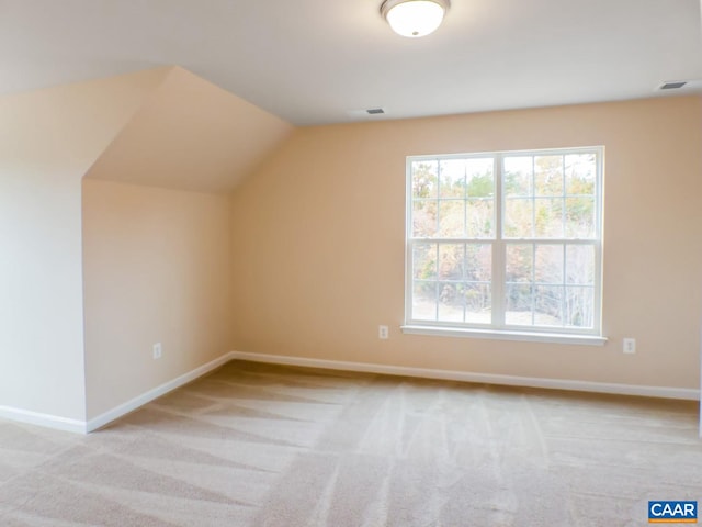 bonus room featuring light carpet and vaulted ceiling