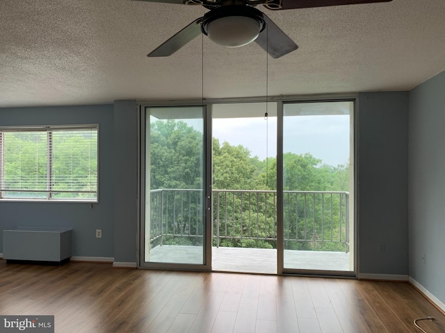 doorway to outside with light hardwood / wood-style flooring, ceiling fan, and a textured ceiling