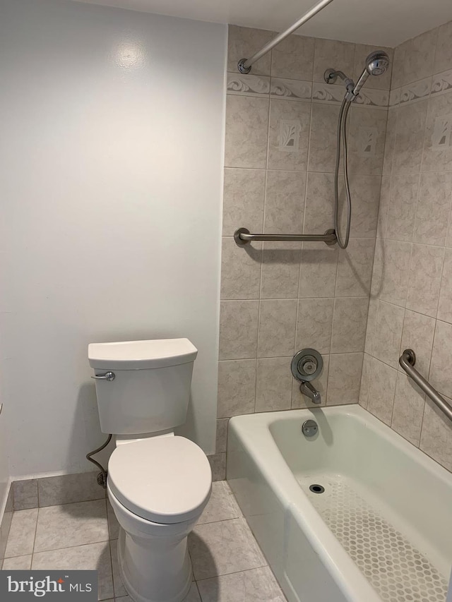 bathroom with tile floors, toilet, and tiled shower / bath