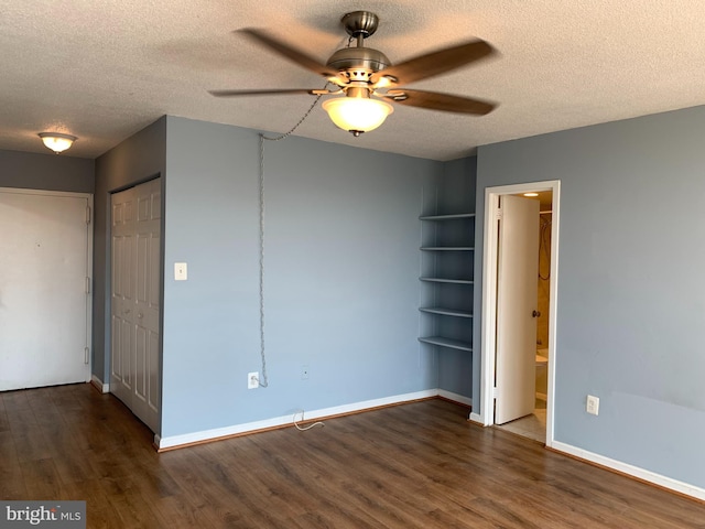 spare room with dark hardwood / wood-style floors, a textured ceiling, and ceiling fan