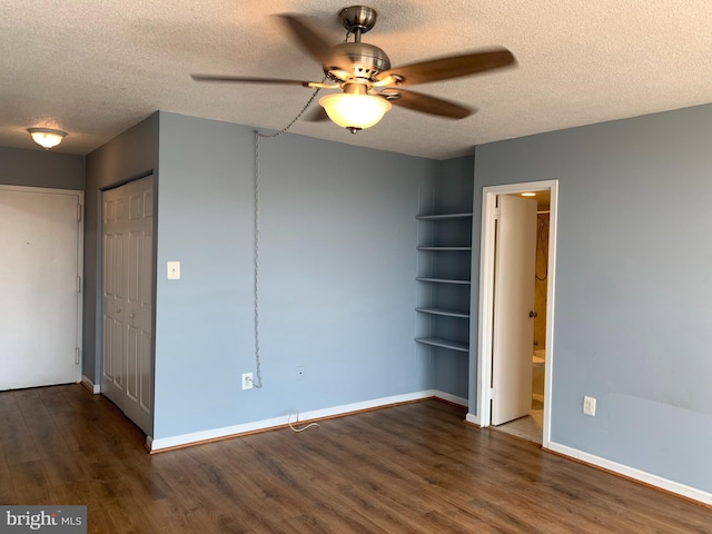 spare room with ceiling fan, dark hardwood / wood-style floors, and a textured ceiling