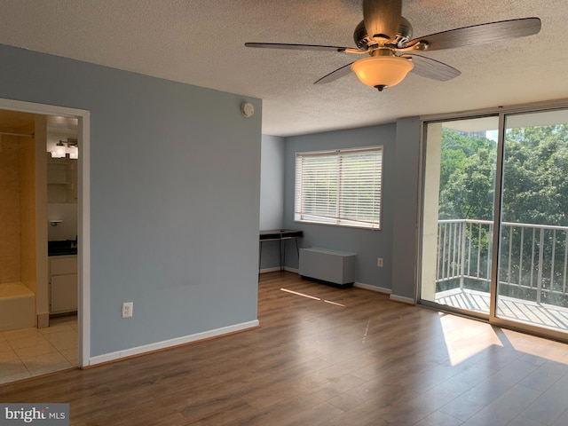 spare room featuring ceiling fan, light tile flooring, and a textured ceiling