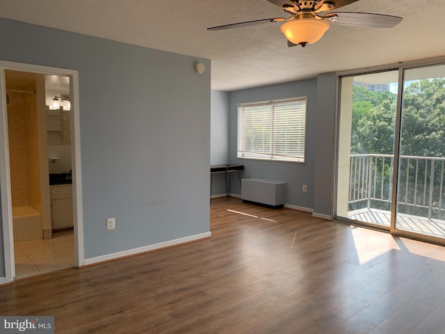 empty room featuring a textured ceiling, ceiling fan, and light hardwood / wood-style flooring