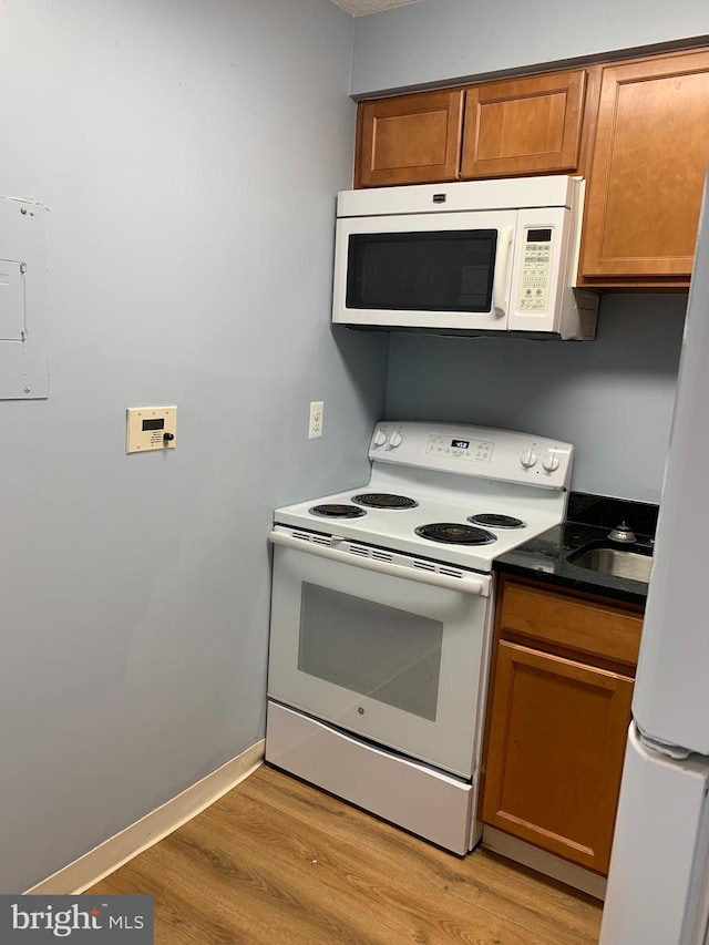 kitchen featuring white appliances and light hardwood / wood-style floors