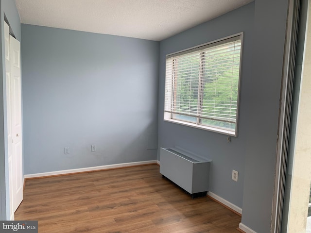 spare room featuring dark hardwood / wood-style floors and a textured ceiling