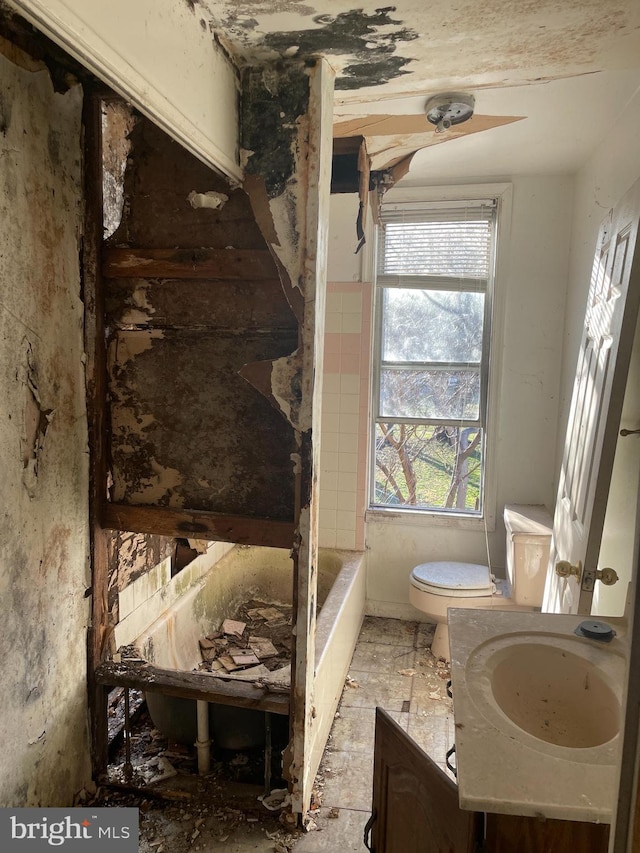 bathroom with toilet, tile floors, and vanity