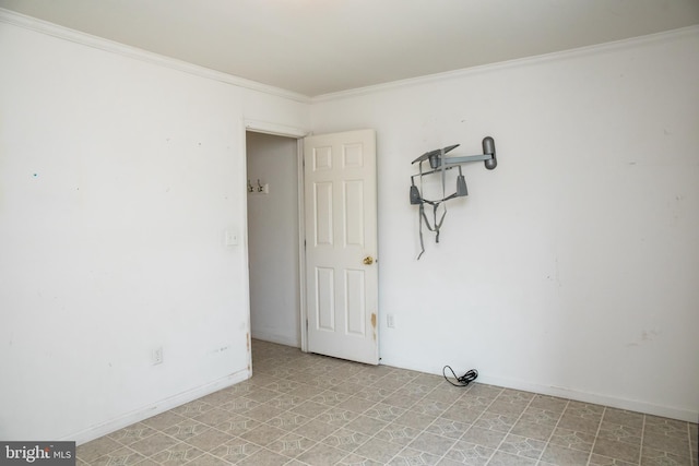 spare room featuring ornamental molding and light tile floors