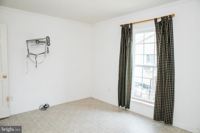 tiled spare room featuring ornamental molding and plenty of natural light