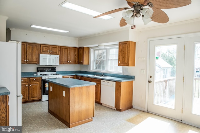 kitchen with light tile flooring, a kitchen island, ceiling fan, white appliances, and sink