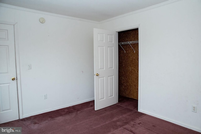 unfurnished bedroom featuring dark carpet, ornamental molding, and a closet