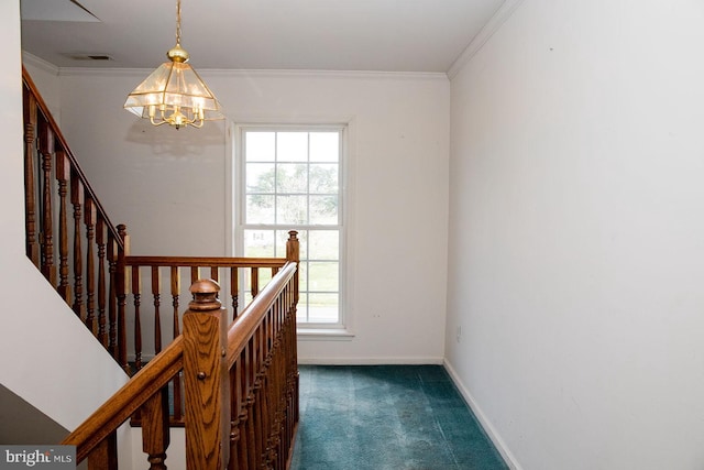 staircase with an inviting chandelier, ornamental molding, and dark carpet