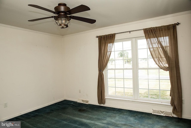 empty room with ornamental molding, ceiling fan, and dark carpet