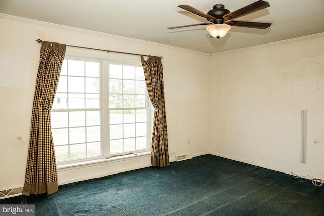 empty room with ceiling fan, dark colored carpet, and ornamental molding