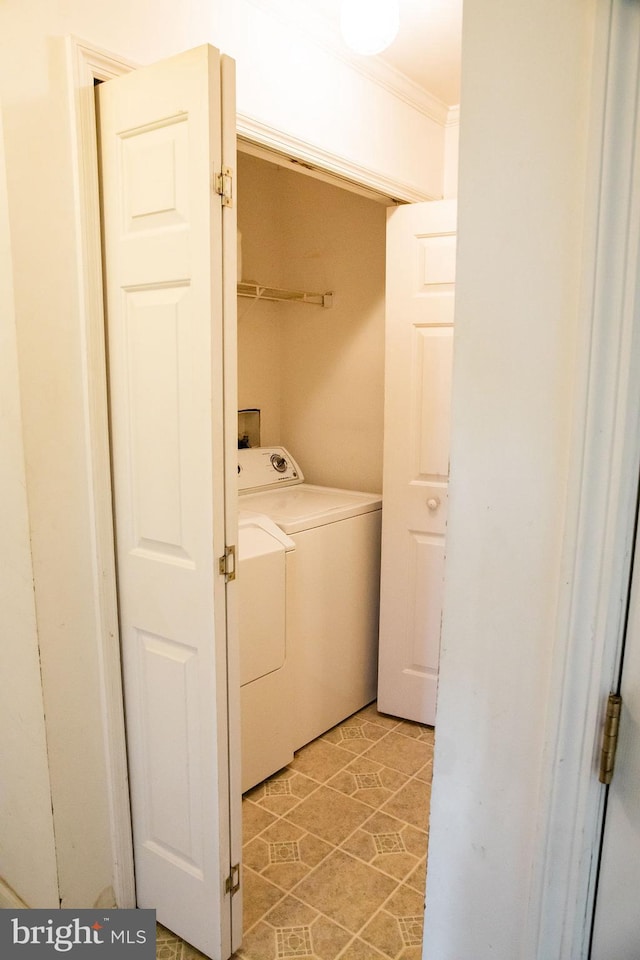 clothes washing area featuring washer hookup, light tile floors, washing machine and clothes dryer, and crown molding