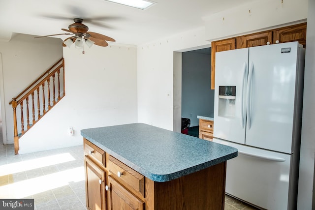 kitchen featuring light tile floors, a kitchen island, white fridge with ice dispenser, and ceiling fan