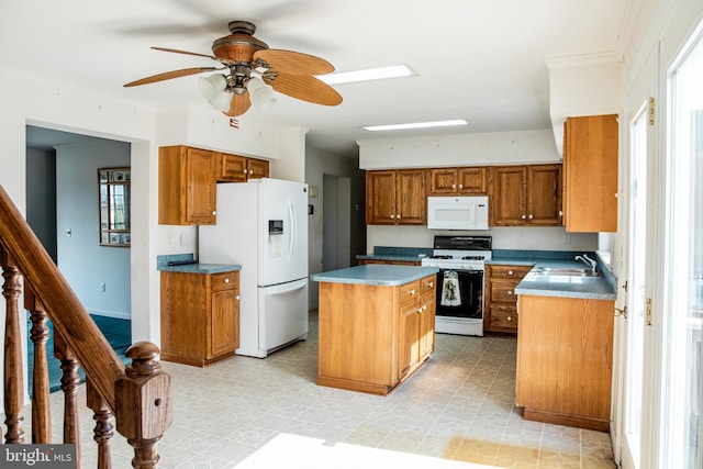 kitchen with white appliances, sink, ceiling fan, light tile floors, and a center island