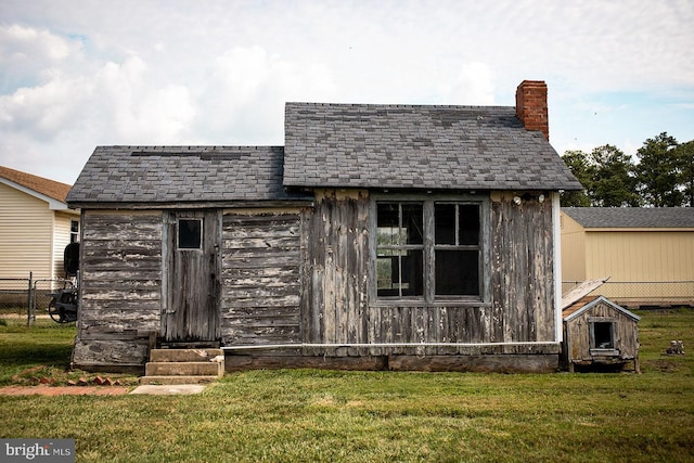 view of front of home with an outdoor structure and a front yard