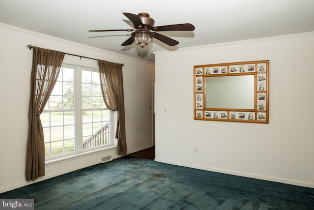 spare room with plenty of natural light, dark colored carpet, ceiling fan, and ornamental molding